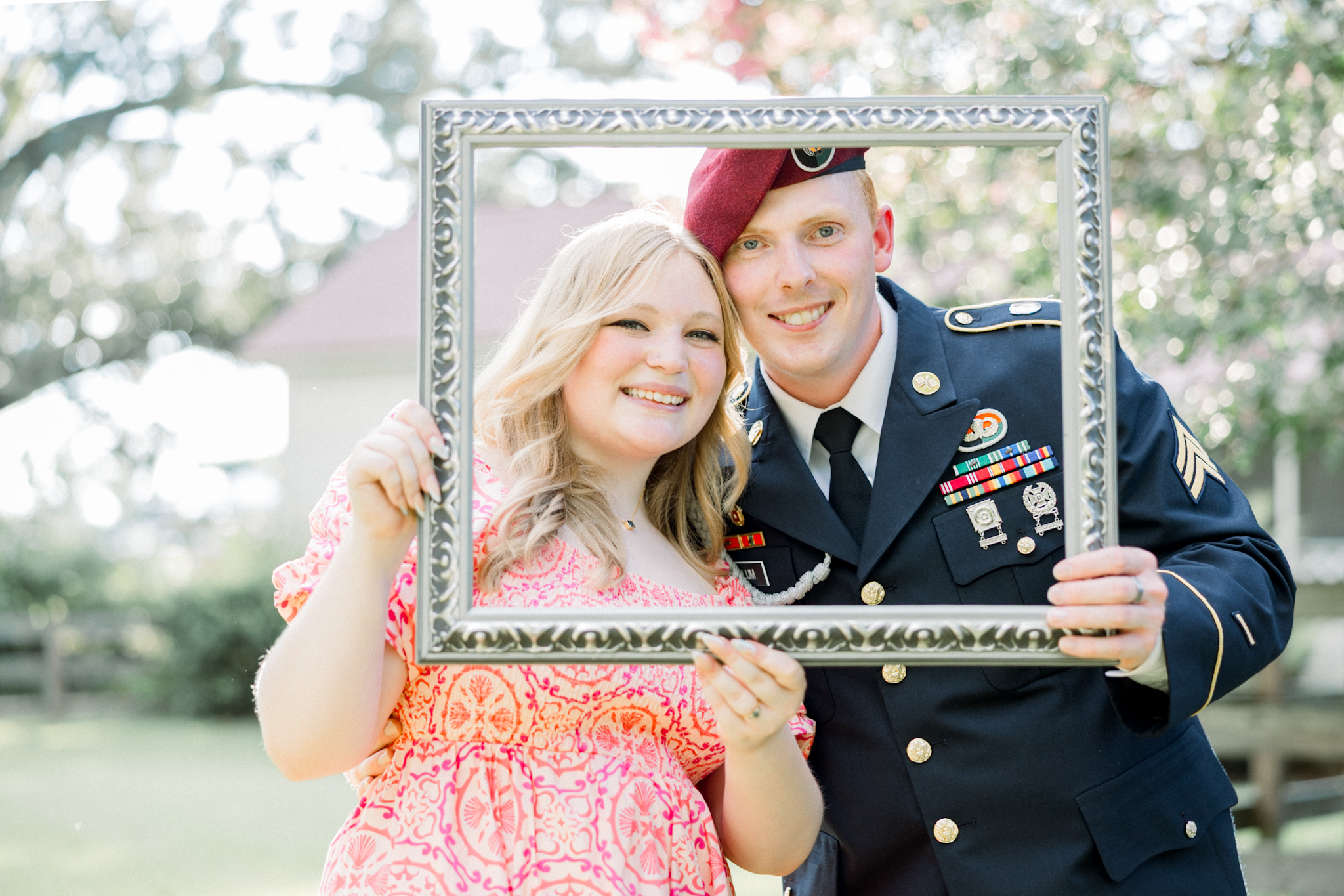 Couple posing with a vintage frame together at Gillis Hill Farm in Fayetteville, NC during their rustic summer engagement session.