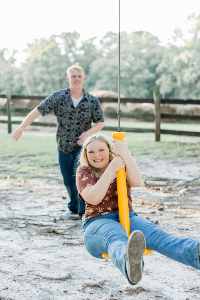 Couple playing on the zip line during their engagement session at Gillis Hill Farm