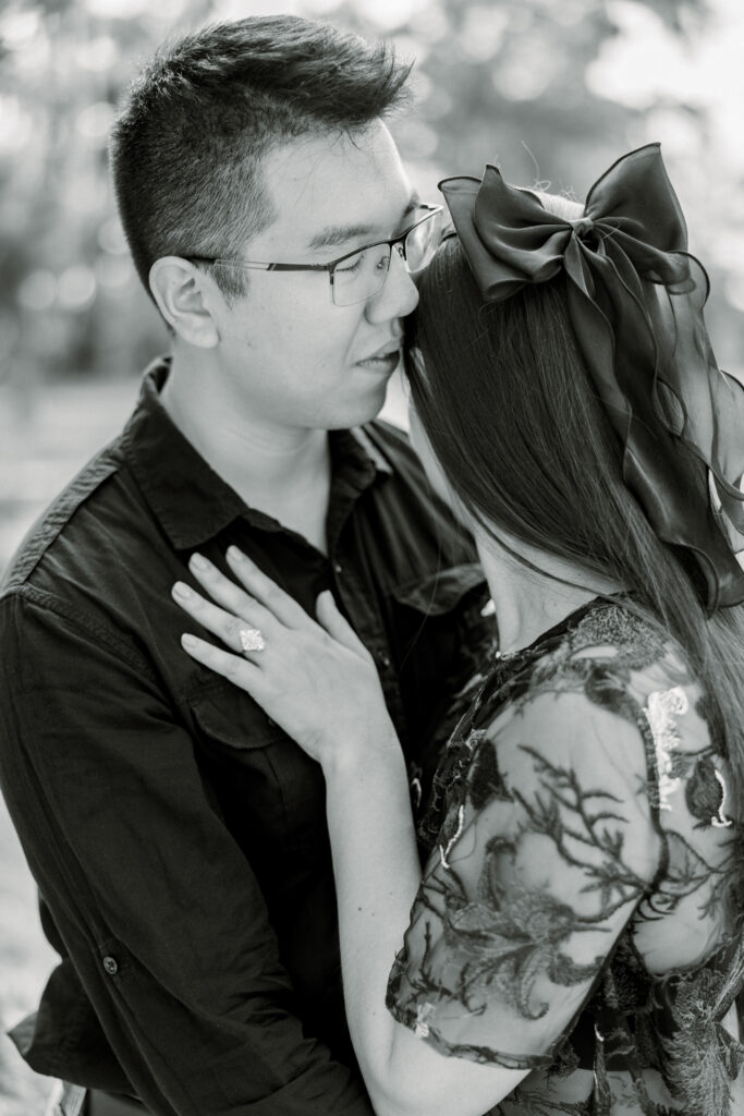 Black and white photo of couple hugging, eyes closed, with peaceful expressions