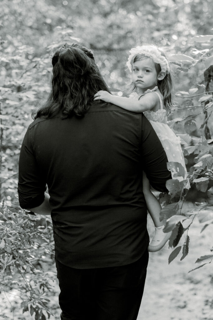 Father and daughter walking through forest